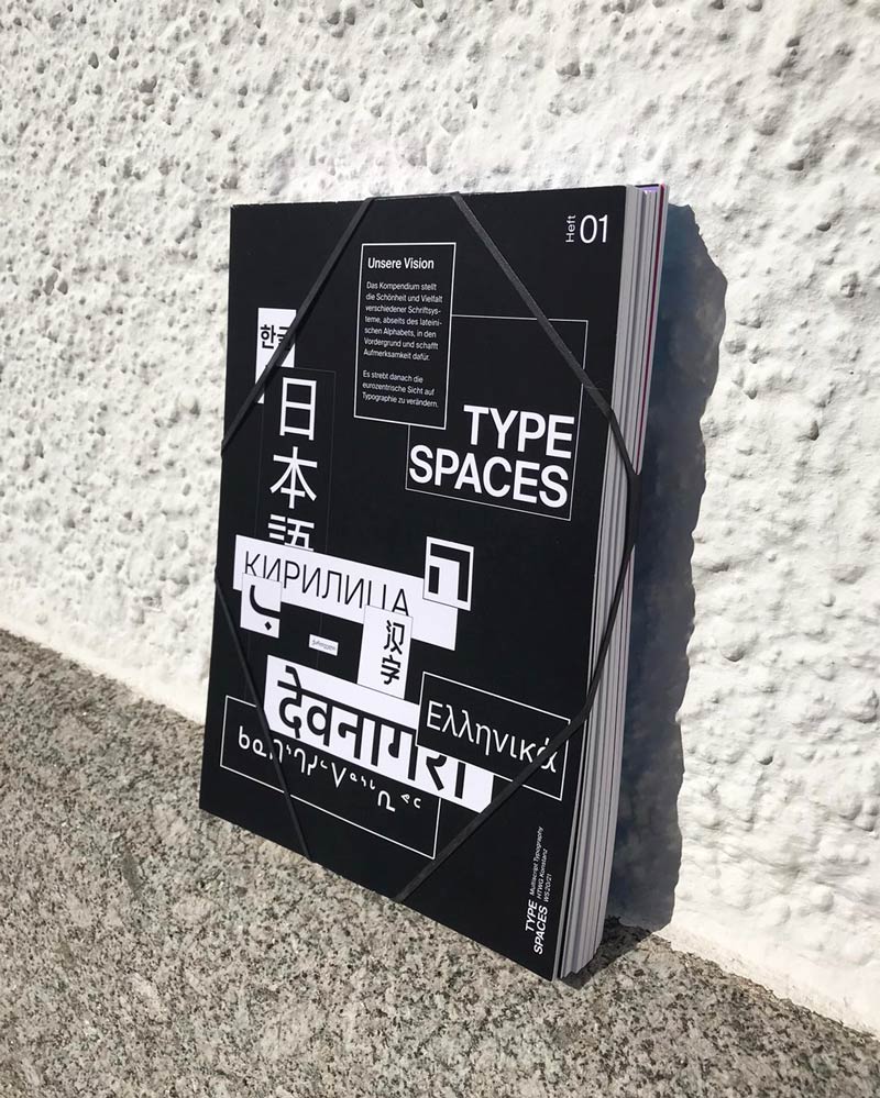 eleven magazines bundled with a rubber band lean against a stonewall